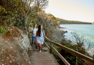 a couple enjoying the walk from Spit Bridge to Manly with scenic views across Sydney Harbour