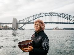 Margret Campbell standing in front of the Sydney Harbour Bridge. (Image: Destination NSW and Margret Campbell)