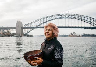 Margret Campbell standing in front of the Sydney Harbour Bridge. (Image: Destination NSW and Margret Campbell)