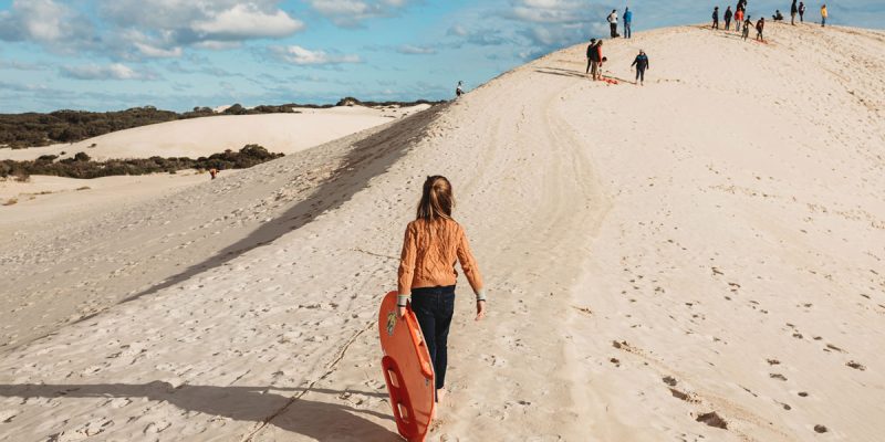 Girl carrying bodyboard at Little Sahara adventure centre