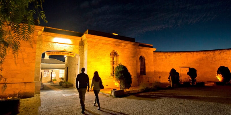 two people entering Old Mount Gambier Gaol at night