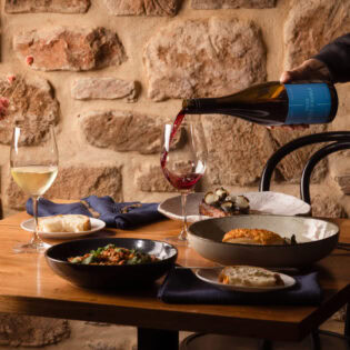 pouring wine into a glass on the dinner table at O’Leary Walker Restaurant