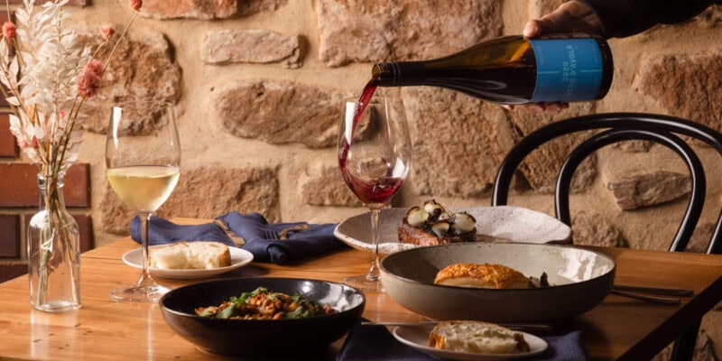 pouring wine into a glass on the dinner table at O’Leary Walker Restaurant