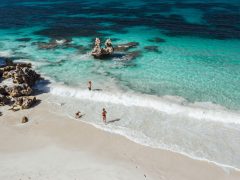 People and dog walking into ocean at Vivonne Bay.