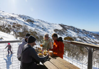 friends dining on the outdoor deck of Black Sallees, Thredbo
