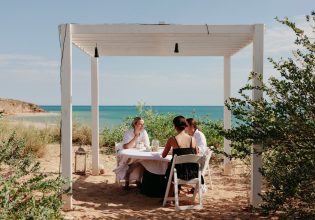 friends dining on the beachfront of Eco Beach Resort