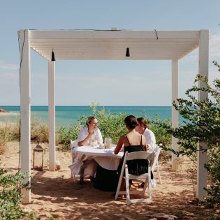 friends dining on the beachfront of Eco Beach Resort