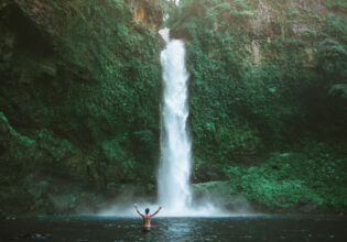 a man standing in front of Nandroya Falls, Cairns