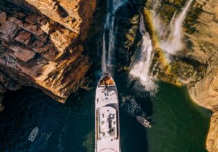People gather on the deck under King George Falls in the Kimberley on a True North cruiise