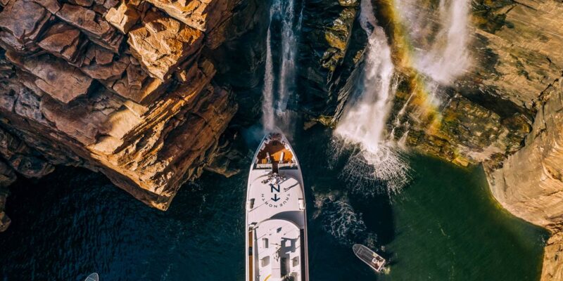 People gather on the deck under King George Falls in the Kimberley on a True North cruiise