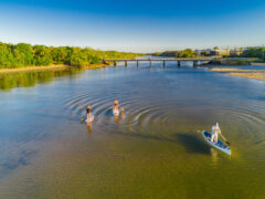 Pottsville South Caravan Park with women on paddleboarding on Boyds Bay