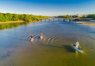 Pottsville South Caravan Park with women on paddleboarding on Boyds Bay