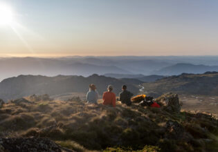 Three people oat the summit of Ramshead Hike in Kosciuszko National Park