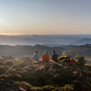 Three people oat the summit of Ramshead Hike in Kosciuszko National Park