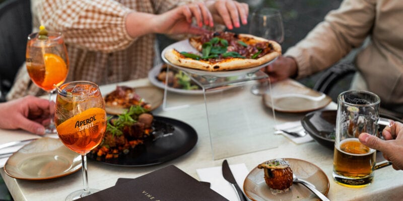 a group of people eating pizza with Aperol spritz at Vine & Tap Wine Bar, Bathurst