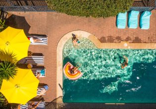 an overhead shot of people swimming in the pool at YHA Byron Bay