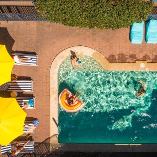 an overhead shot of people swimming in the pool at YHA Byron Bay