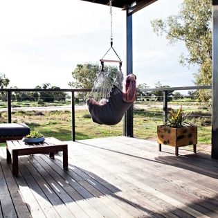 Woman sitting in a swing hammock in Callubri Station, NSW, Australi
