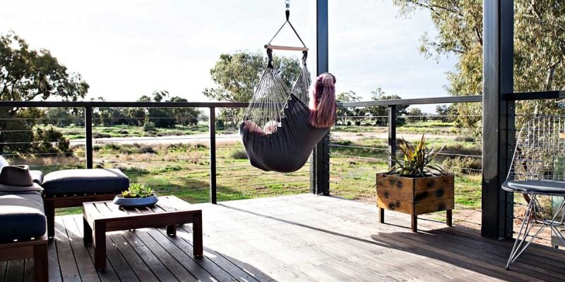 Woman sitting in a swing hammock in Callubri Station, NSW, Australi
